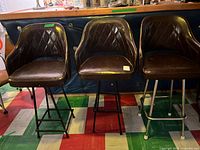 Front view of all three bar stools showing upholstery and bases