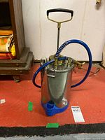 Full view of stainless steel manual pump sprayer with hose, wand and base
