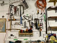 Wide view of pegboard showing full assortment of hand tools and extension cords