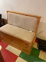 Front view of wood storage bench with upholstered seat and back