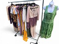Full rack of assorted women’s boho garments on hangers with mannequin displaying green lace dress