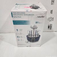 Retail box front showing Babymoov Turbo Pure Sterilizer & Dryer branding and features