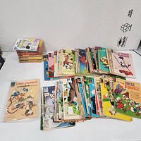 Overall view of multiple piles of Gold Key comics and digests spread on tabletop