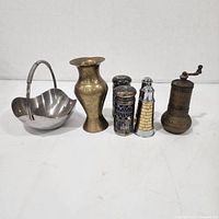 Group shot of all seven items: handled bowl, brass vase, two cobalt shakers, two lighthouse shakers, brass grinder
