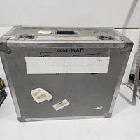 Front view of gray aluminum flight case showing reinforced corners and wear