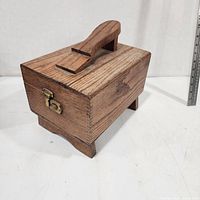 three-quarter view of wooden shoe shine box showing foot rest handle and latch