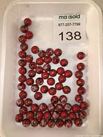Tray showing quantity of red cloisonné beads