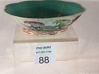 Side view showing scalloped rim, turquoise interior and exterior floral decoration