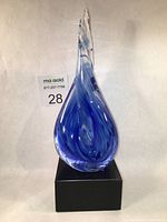 Full view of blue spiral blown glass sculpture on black marble base