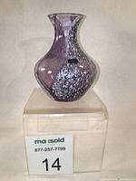 Front view of Caithness purple swirl bud vase with original label visible