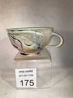 Right profile of porcelain mug showing handle and glaze pattern