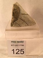 Side profile of soapstone head sculpture on clear stand