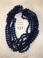 All six strands of sapphire blue faceted beads coiled together