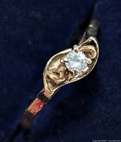 Close-up of ring emphasizing diamond setting and gold motif