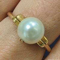 Ring on finger showing pearl and band detail