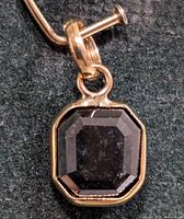 Close-up of emerald-cut black diamond pendant in bezel setting