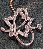 Front view of 14K gold pendant showing star and ribbon design with cubic zirconia