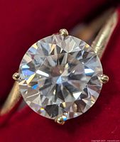 Close-up of 2 ct round brilliant moissanite in four-prong 10K gold setting