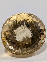 Front view of round faceted citrine showing colour and cut