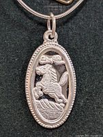 Close-up of oval horse pendant front detail