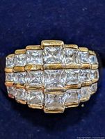 Front view of ring showing four rows of square CZ stones and gold-tone finish
