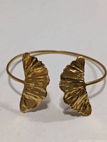 Full view of open bangle showing twin textured leaf ends