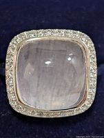 Front view of ring showing rose quartz cabochon and halo of accent stones