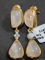 Front view of both earrings showing cabochon stones and accent stones