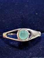 Front view of silver ring showing emerald cabochon and split-shank design