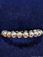 Side view of beaded silver ring on dark blue background