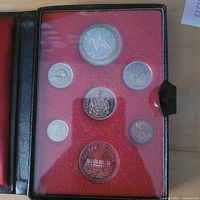 Open presentation case displaying all seven coins in plastic panel