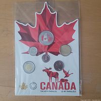 Front of sealed 49th Parallel coin set showing all coins and maple leaf backing