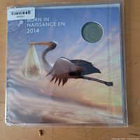 Front of sealed 2014 Born in 2014 coin set packaging showing stork image and encapsulated coin