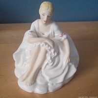 Front view of Royal Doulton Joanne figurine showing seated pose, dress and facial details