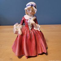 Front view of Royal Doulton Lavinia figurine showing dress, pose and bonnet