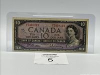 Obverse of banknote in sleeve showing portrait, denomination, serial number