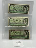 Fronts of three 1967 $1 notes in sleeve, showing Queen Elizabeth II and commemorative text