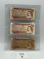 Fronts of three 1974 $2 Bank of Canada notes in plastic sleeve