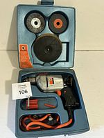 Open case showing drill, cord, red bit holder, three discs