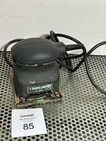 Front view of Black & Decker palm sander showing housing and cord