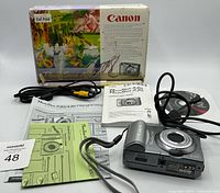 Box, camera, cables, manuals and paperwork layout