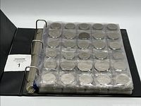 binder with pages of silver-tone coins in plastic pockets