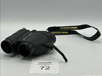Front angled view of Nikon Travelite binoculars showing strap and eyepieces
