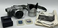 Camera with accessories including charger, SD cards, lens hood, manual