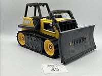 Three-quarter view of yellow and black Tonka bulldozer with grey blade