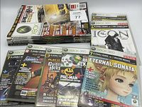Stack of Official Xbox Magazine issues with disc #77 visible plus spread of demo discs