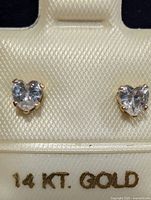 Front view of heart-shaped cubic zirconia studs in 14K gold settings on display card