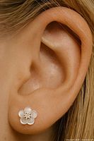 Earring worn in ear showing flower design