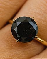 Close-up of black diamond in four-prong gold setting