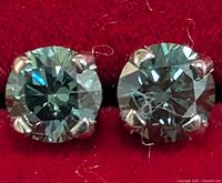Front view of both diamond stud earrings in red box